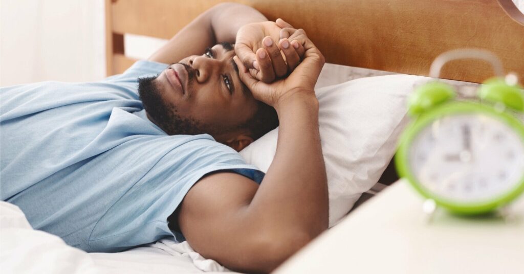 Japan Sleep man in bed with alarm clock in foreground