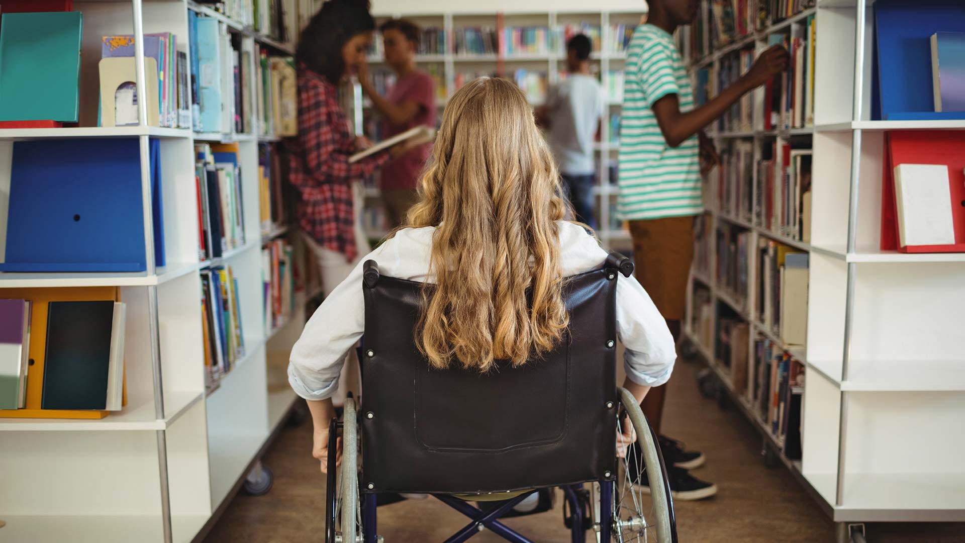 Girl in wheelchair in school library