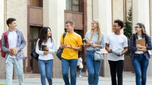 Multiracial students walking in front of university building
