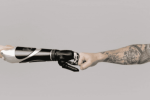 Fist bump between robot hand and human hand with tattoos