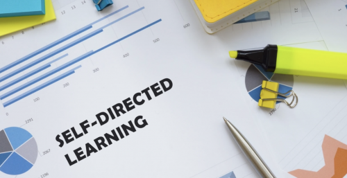 Office supplies, papers and a highlighter on a desk