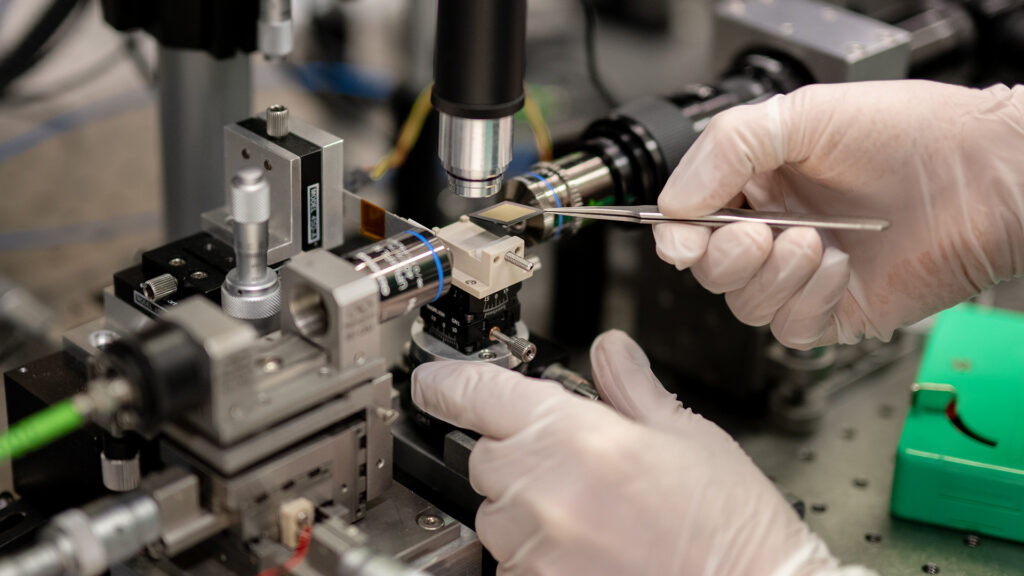 Gloved hands with tool working on complicated machinery
