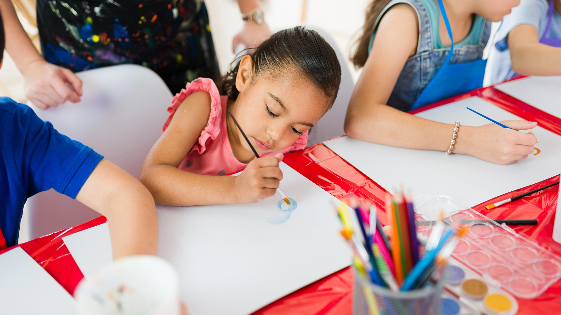 A young girl paints a picture. 