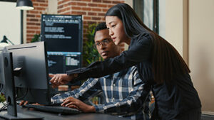 Two colleagues pointing at a computer screen