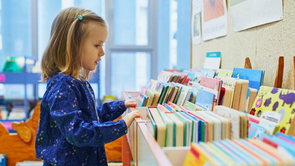 Child examining a collection of books