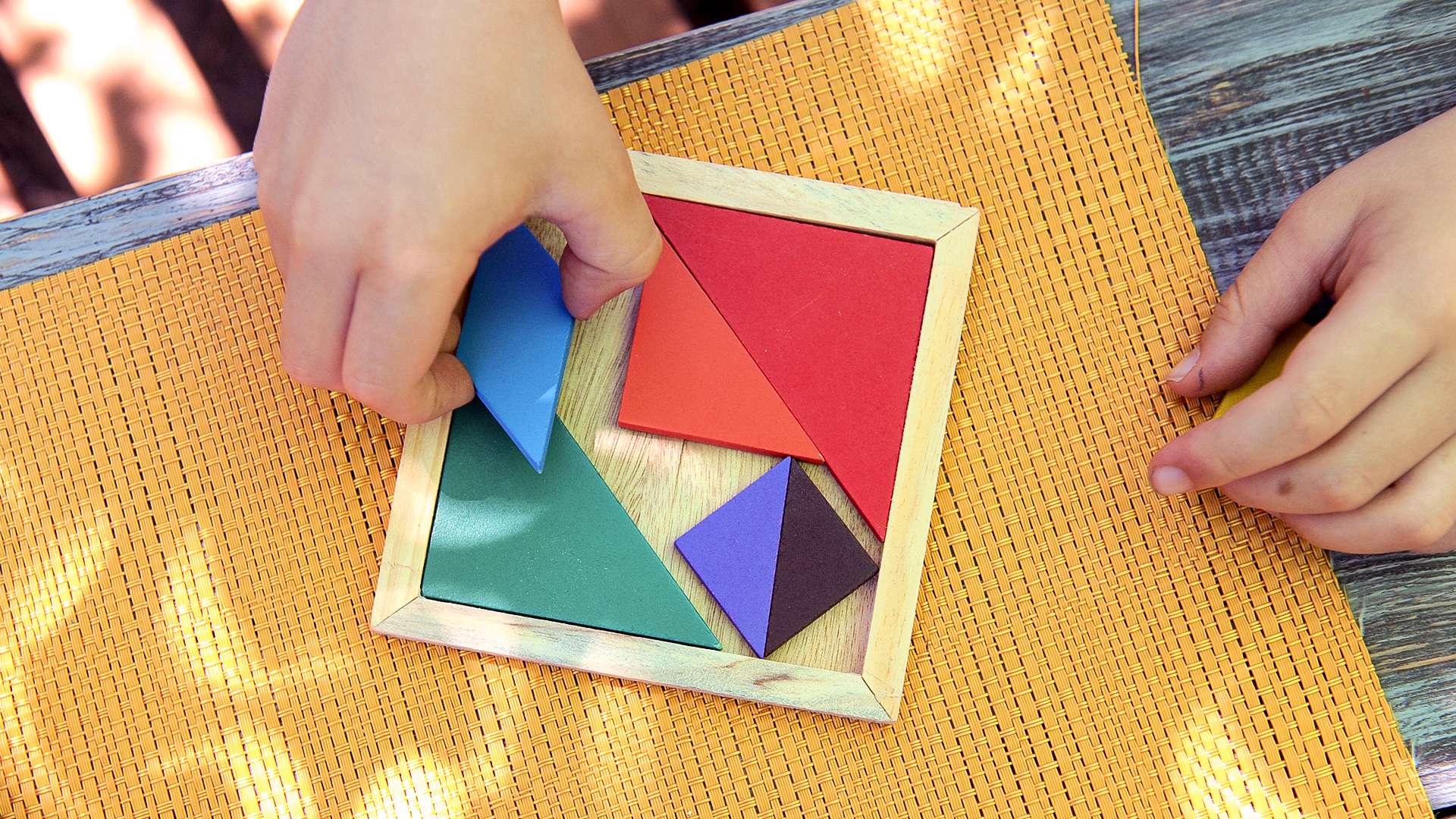 Child playing with tangram puzzle