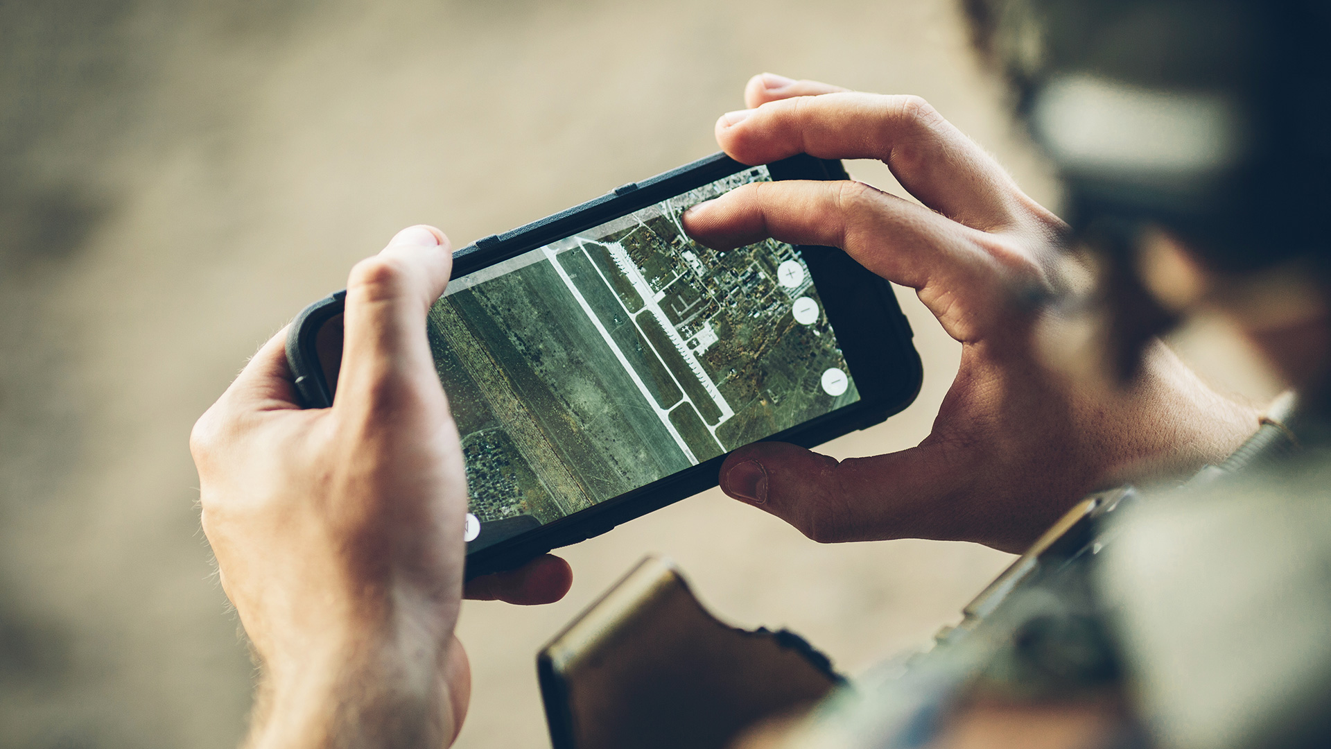 Soldier looking at a high-tech mapping app on a mobile phone