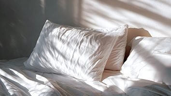 Pillows on bed in sunlight
