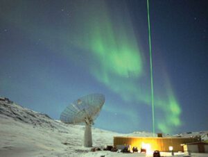 Satellite dish in front of aurora borealis